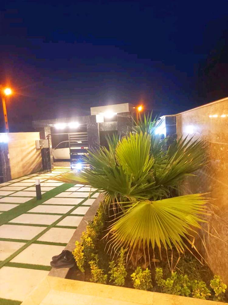 تصویر یک ویلای نما مدرن و محوطه سازی شده با موزاییک و چمن مصنوعی