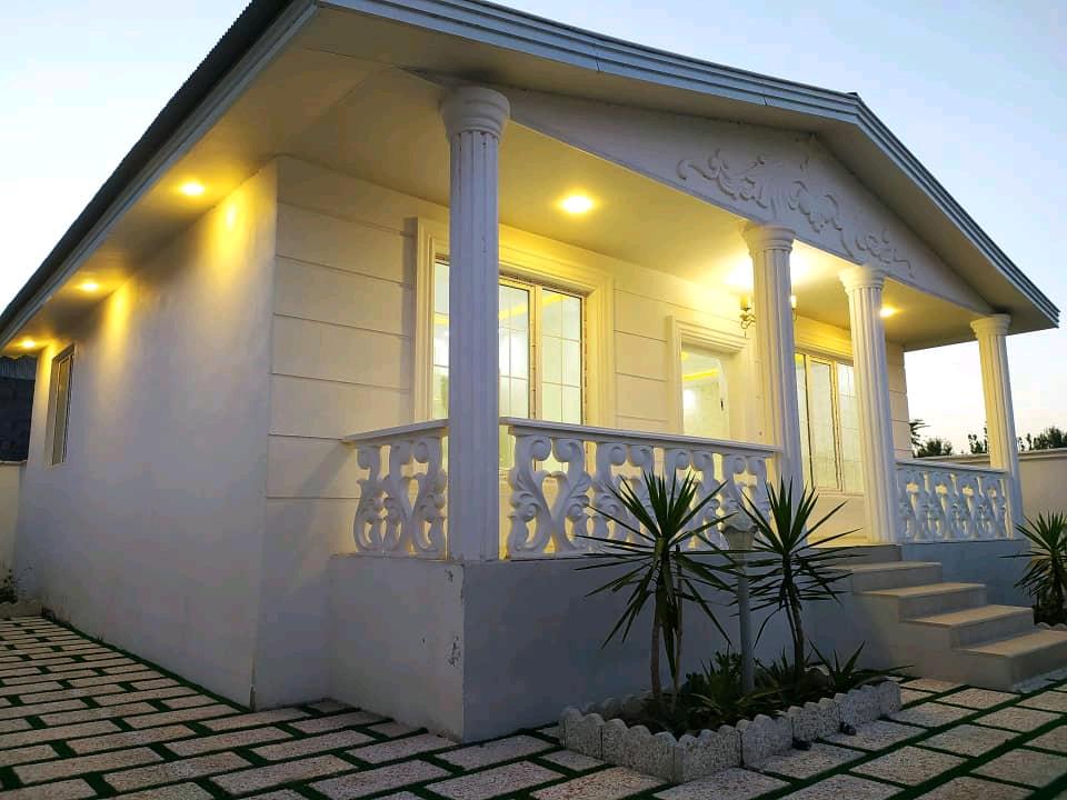 تصویر یک ویلای فلت روستایی که محوطه سازی شده و از چمن مصنوعی استفاده شده