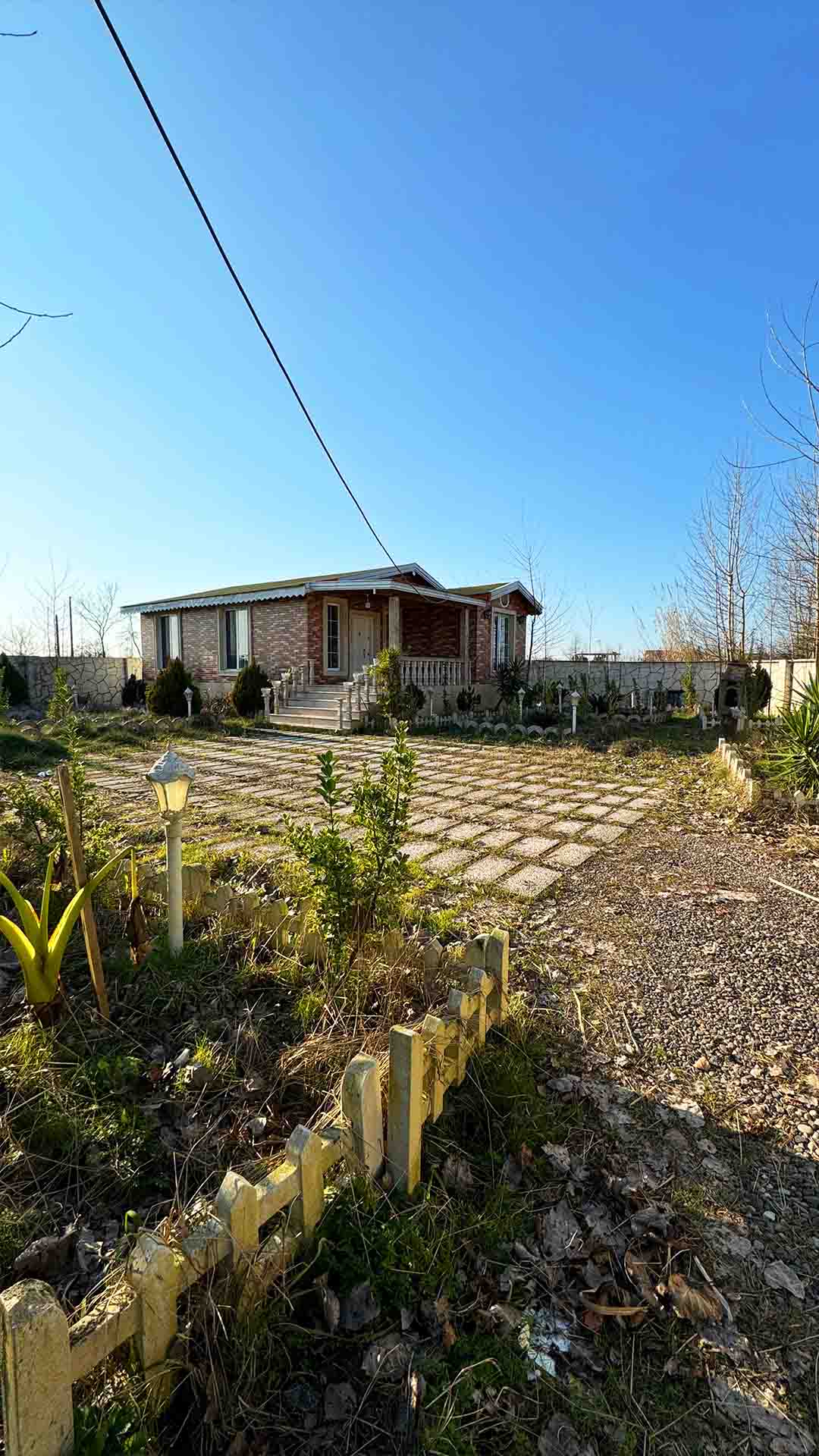 تصویر یک ویلای فلت روستایی که محوطه سازی شده و از چمن مصنوعی استفاده شده