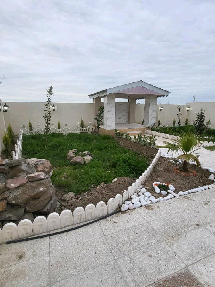 تصویر یک ویلای نما مدرن و محوطه سازی شده با موزاییک و چمن مصنوعی