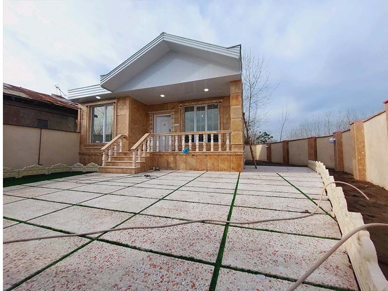 تصویر یک ویلای نما کلاسیک و محوطه سازی شده با موزاییک و چمن مصنوعی