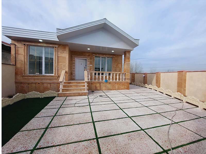 تصویر یک ویلای نما کلاسیک و محوطه سازی شده با موزاییک و چمن مصنوعی