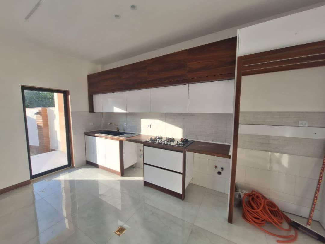 تصویر یک ویلای نما مدرن و محوطه سازی شده با موزاییک و چمن مصنوعی