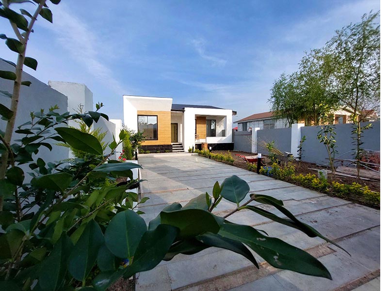 تصویر یک ویلای نما مدرن و محوطه سازی شده با موزاییک و چمن مصنوعی