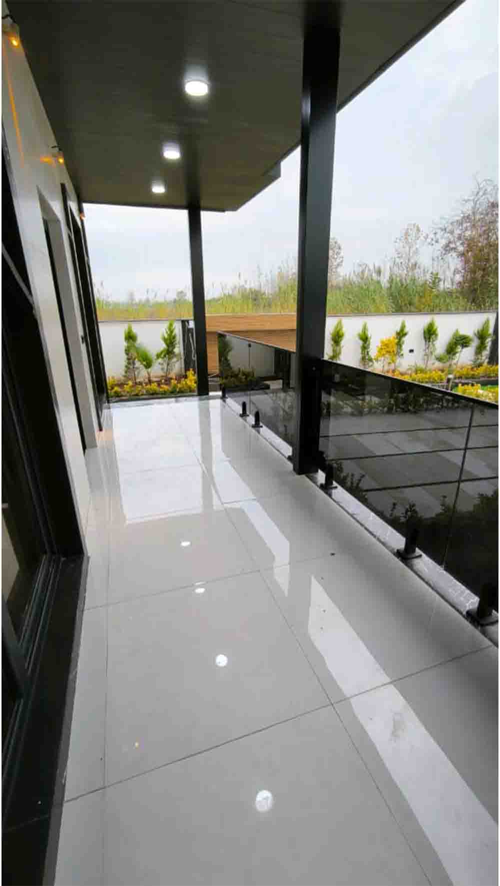 تصویر یک ویلای نما مدرن و محوطه سازی شده با موزاییک و چمن مصنوعی