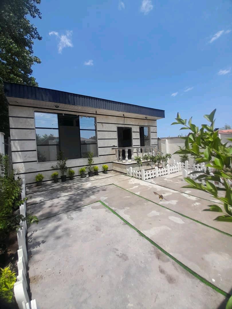 تصویر یک ویلای نما مدرن و محوطه سازی شده با موزاییک و چمن مصنوعی