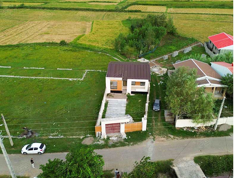 تصویر یک ویلای نما مدرن و محوطه سازی شده با موزاییک و چمن مصنوعی