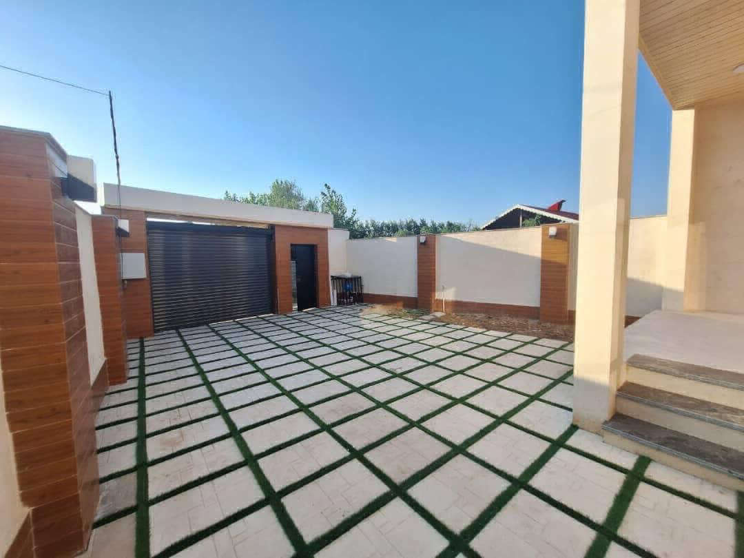 تصویر یک ویلای نما مدرن و محوطه سازی شده با موزاییک و چمن مصنوعی