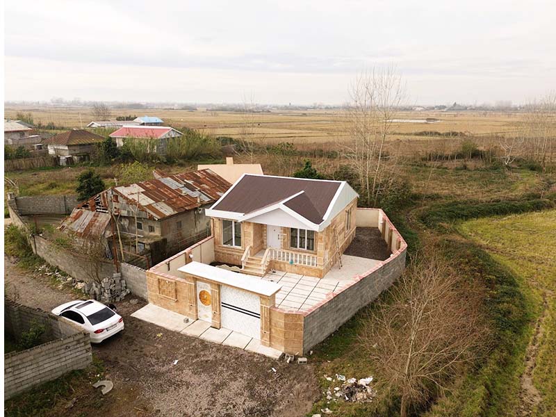 تصویر یک ویلای نما کلاسیک و محوطه سازی شده با موزاییک و چمن مصنوعی