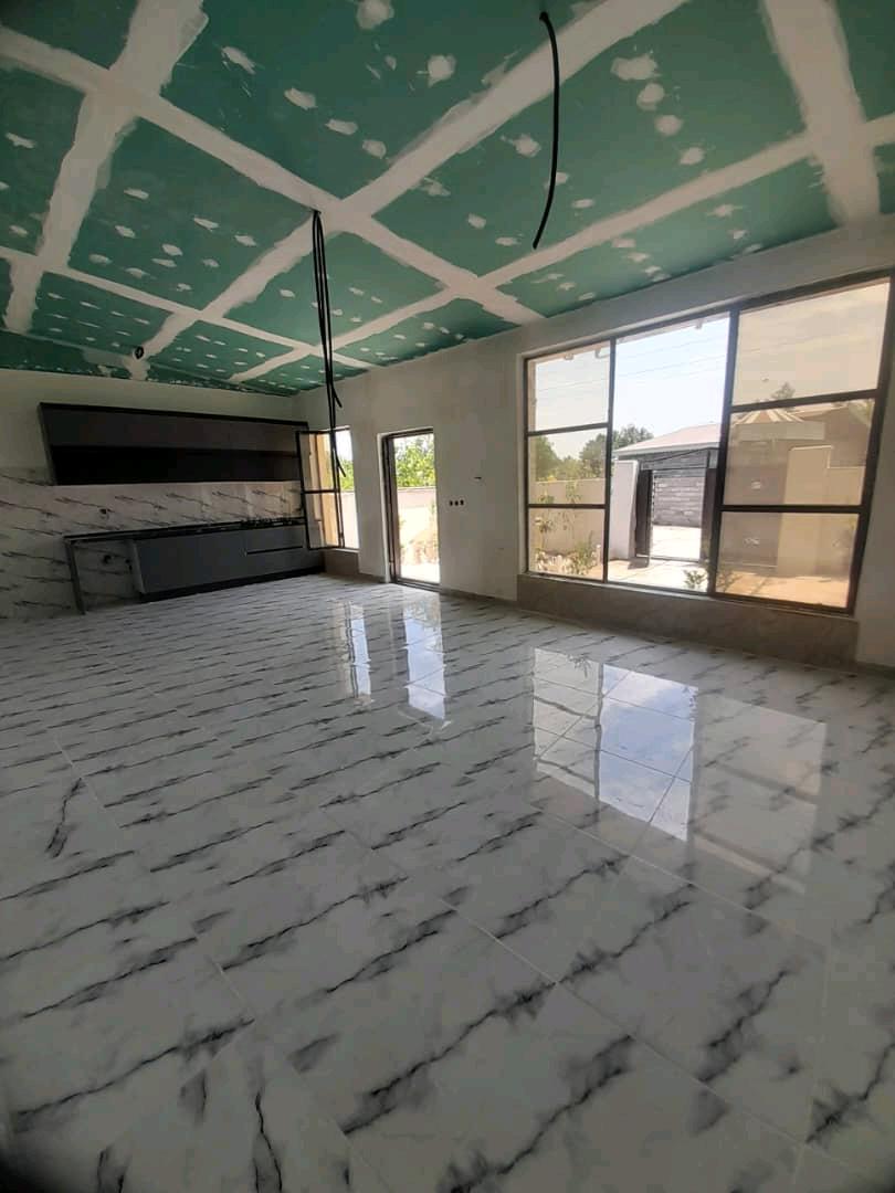 تصویر یک ویلای نما مدرن و محوطه سازی شده با موزاییک و چمن مصنوعی