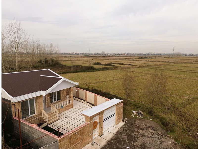 تصویر یک ویلای نما کلاسیک و محوطه سازی شده با موزاییک و چمن مصنوعی