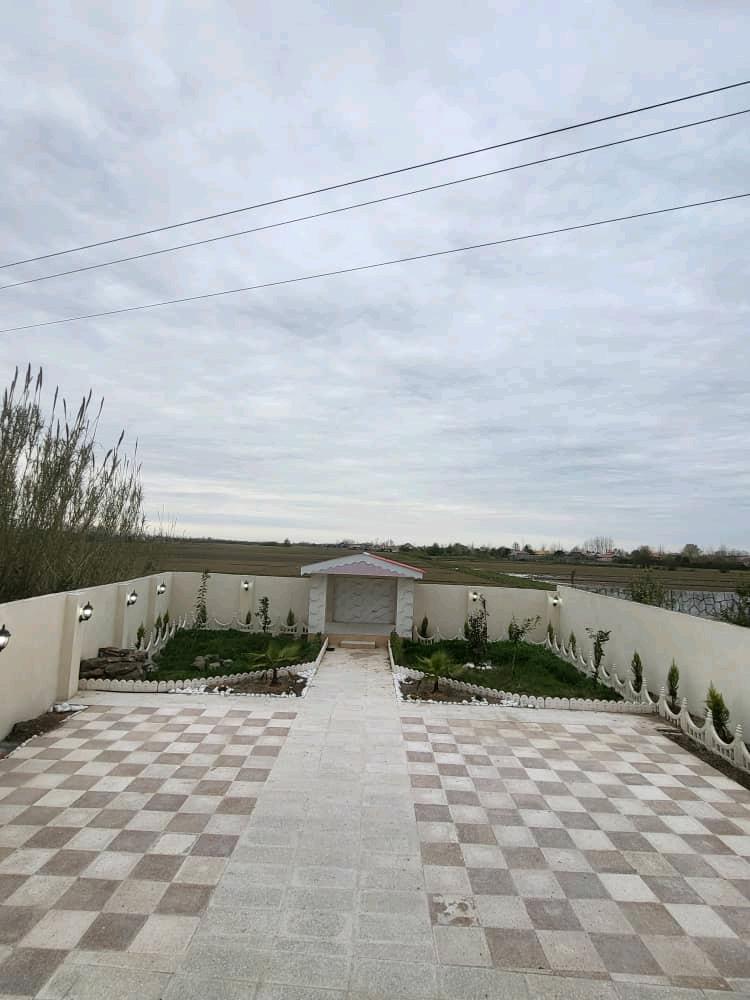 تصویر یک ویلای نما مدرن و محوطه سازی شده با موزاییک و چمن مصنوعی