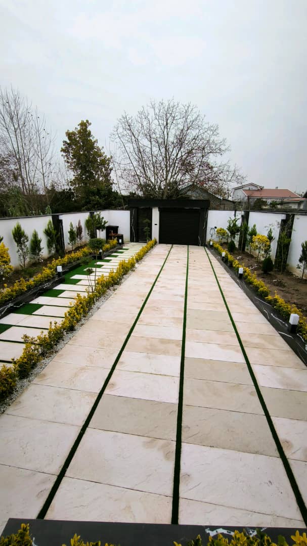 تصویر یک ویلای نما مدرن و محوطه سازی شده با موزاییک و چمن مصنوعی