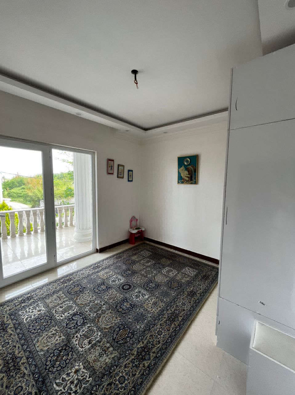 تصویر یک ویلای نما مدرن و محوطه سازی شده با موزاییک و چمن مصنوعی