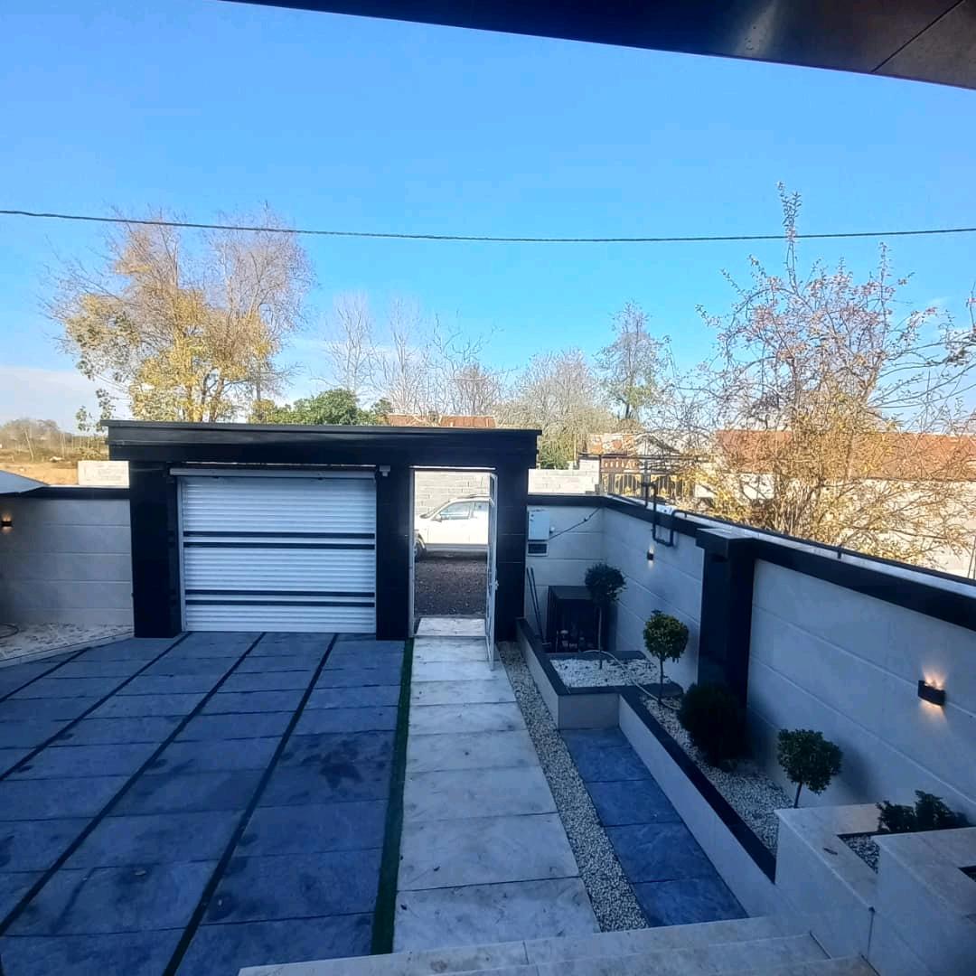 تصویر یک ویلای فلت روستایی که محوطه سازی شده و از چمن مصنوعی استفاده شده