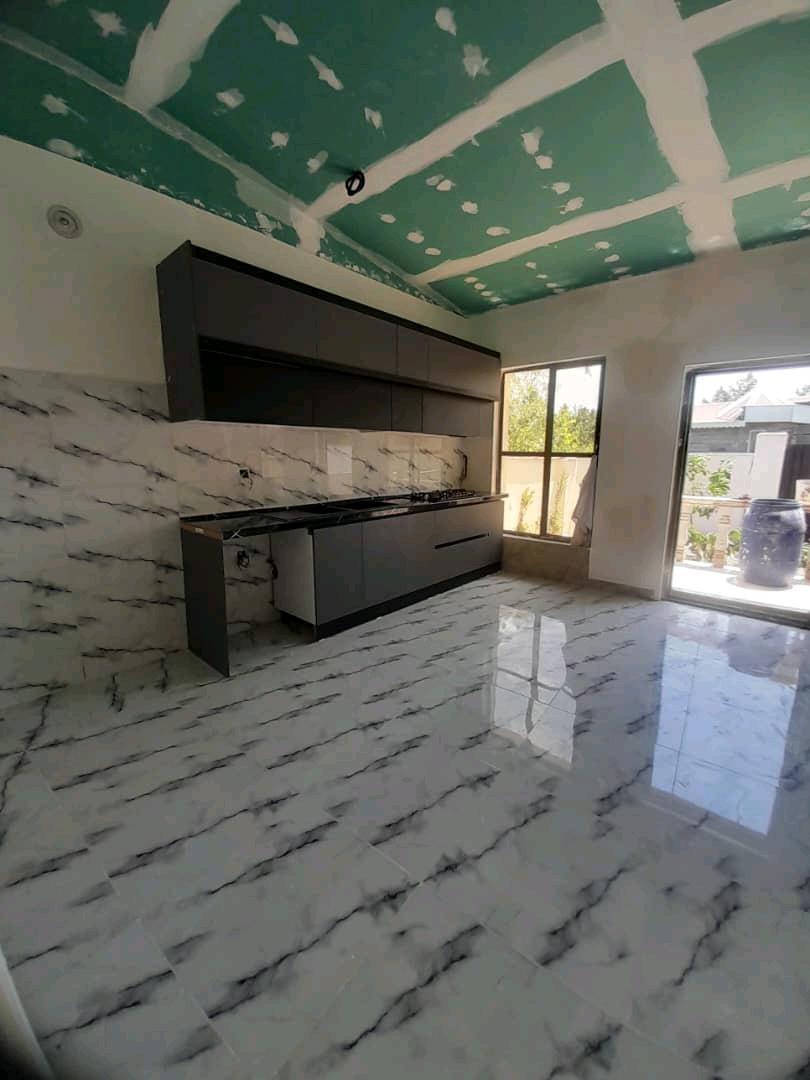 تصویر یک ویلای نما مدرن و محوطه سازی شده با موزاییک و چمن مصنوعی