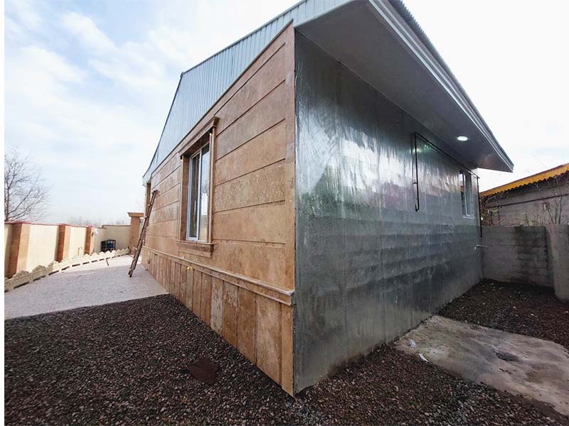 تصویر یک ویلای نما کلاسیک و محوطه سازی شده با موزاییک و چمن مصنوعی