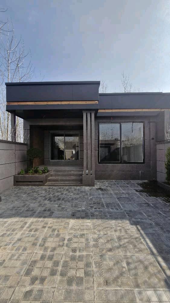 تصویر یک ویلای نما مدرن و محوطه سازی شده با موزاییک و چمن مصنوعی