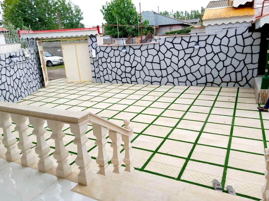 تصویر یک ویلای فلت روستایی که محوطه سازی شده و از چمن مصنوعی استفاده شده