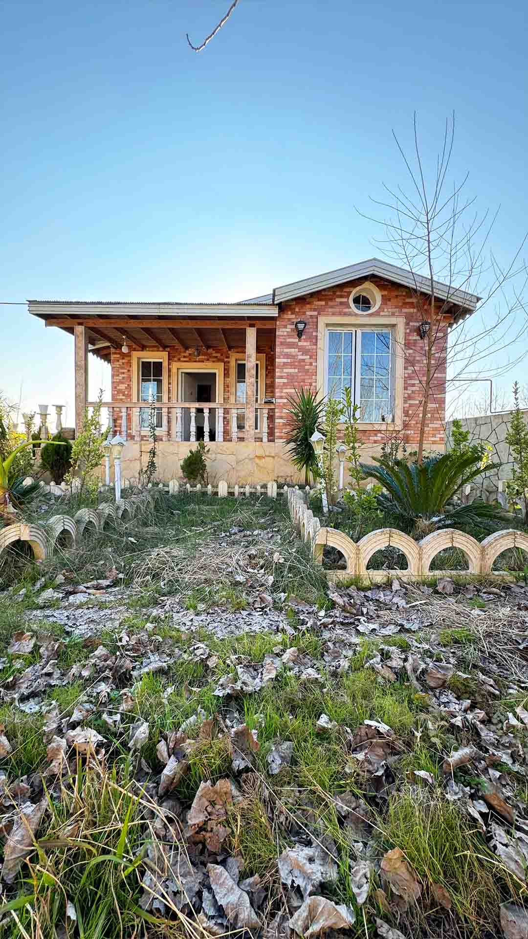 تصویر یک ویلای فلت روستایی که محوطه سازی شده و از چمن مصنوعی استفاده شده