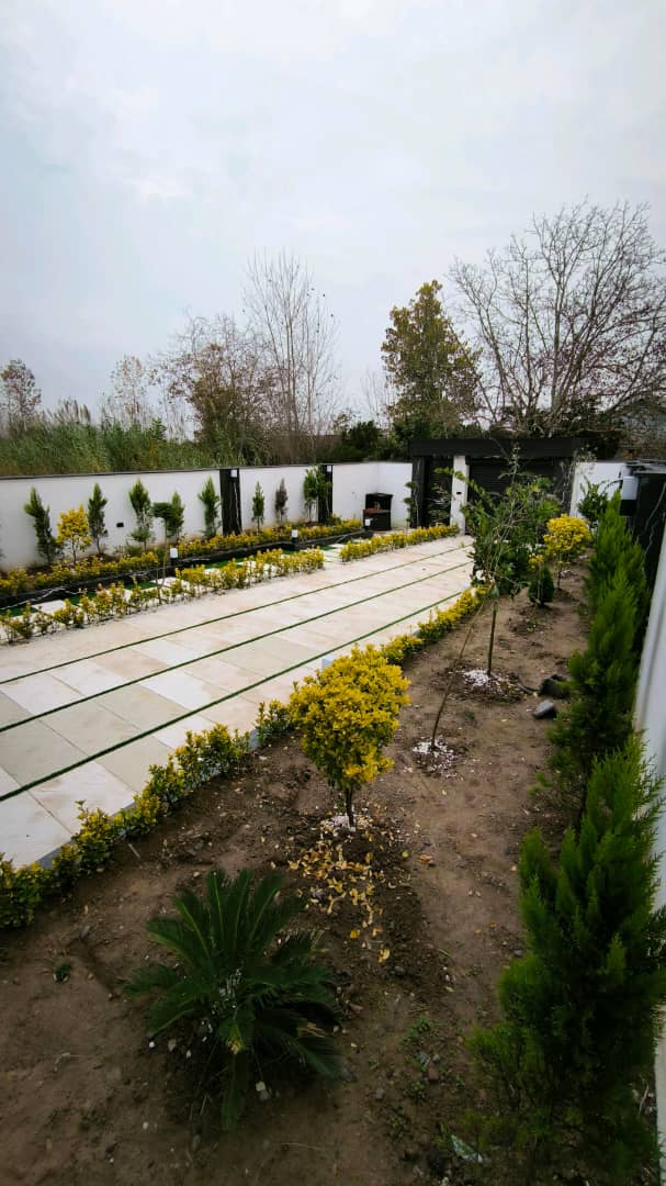 تصویر یک ویلای نما مدرن و محوطه سازی شده با موزاییک و چمن مصنوعی