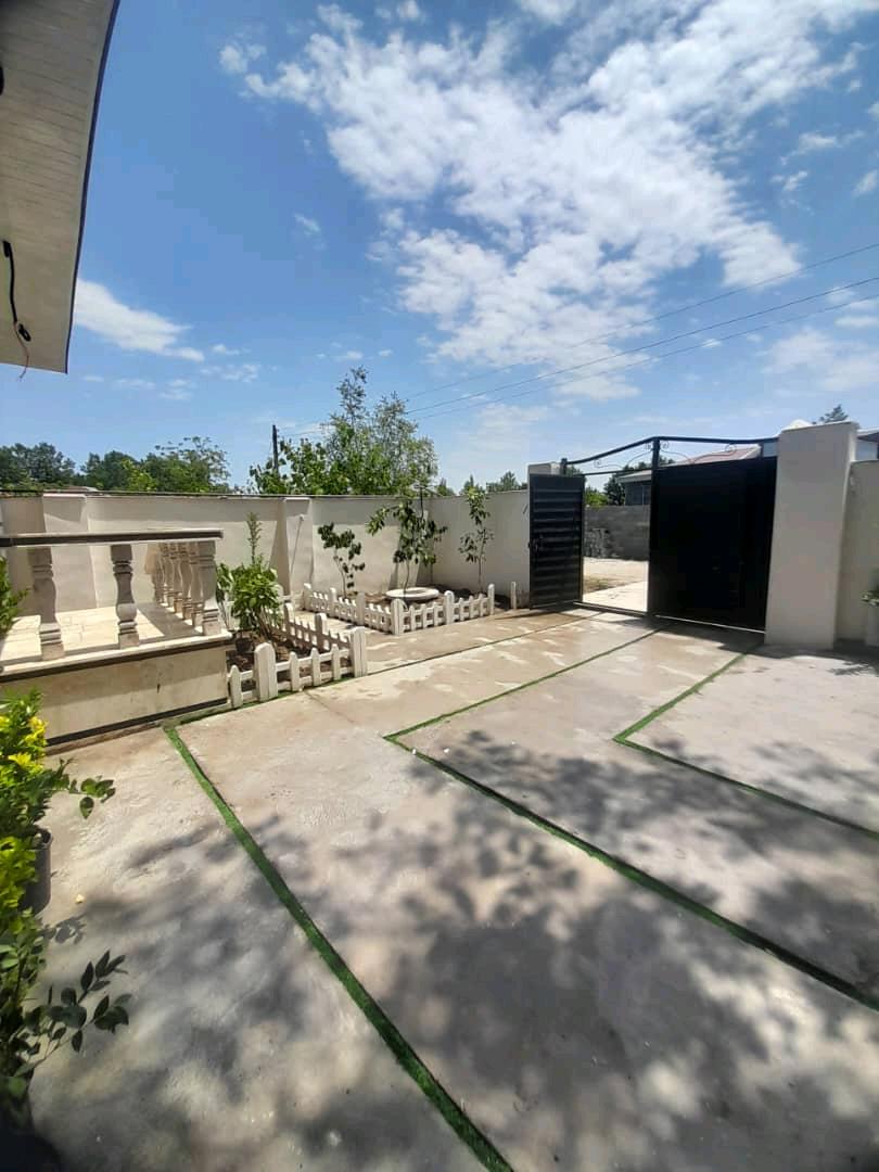 تصویر یک ویلای نما مدرن و محوطه سازی شده با موزاییک و چمن مصنوعی