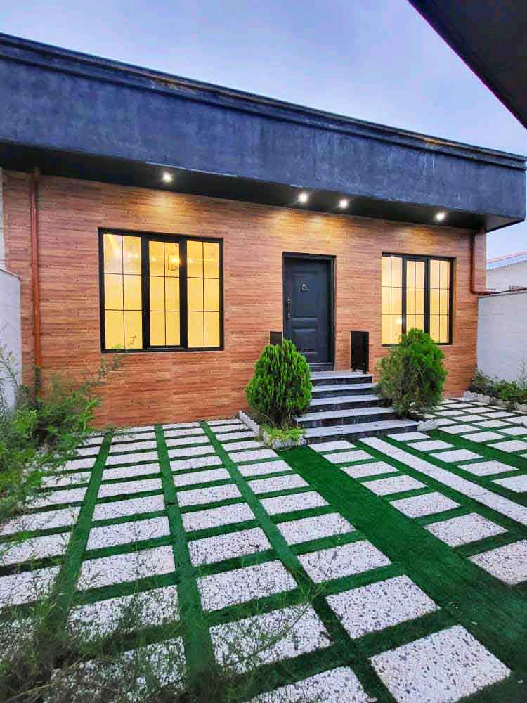 تصویر یک ویلای نما مدرن و محوطه سازی شده با موزاییک و چمن مصنوعی