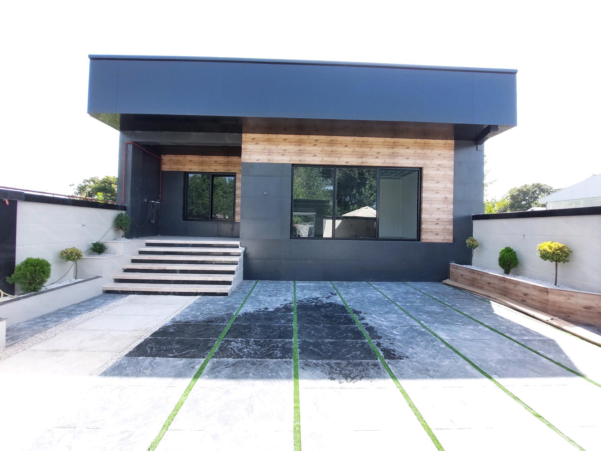 تصویر یک ویلای فلت روستایی که محوطه سازی شده و از چمن مصنوعی استفاده شده