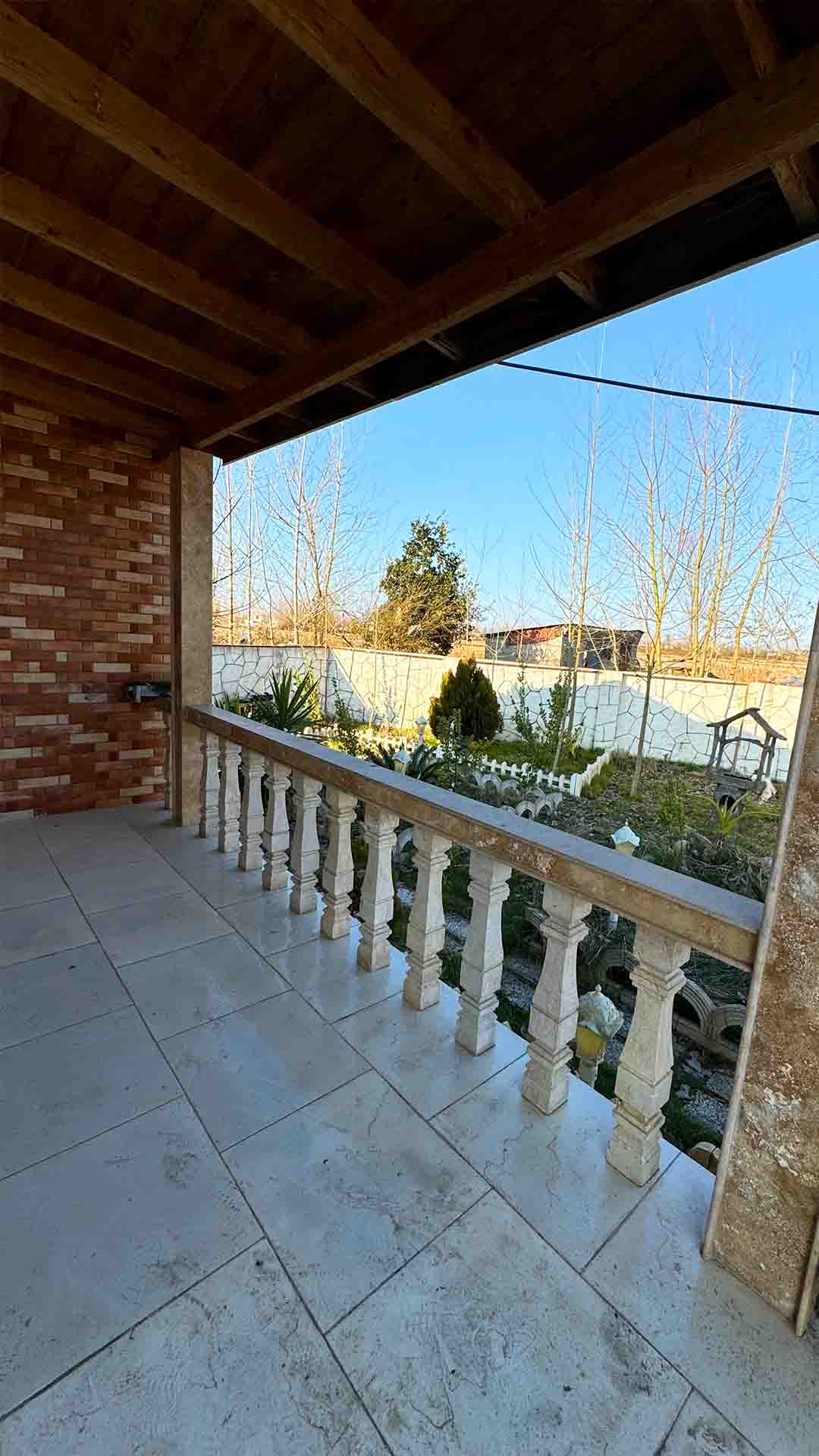 تصویر یک ویلای فلت روستایی که محوطه سازی شده و از چمن مصنوعی استفاده شده