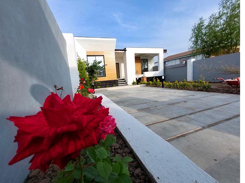 تصویر یک ویلای نما مدرن و محوطه سازی شده با موزاییک و چمن مصنوعی