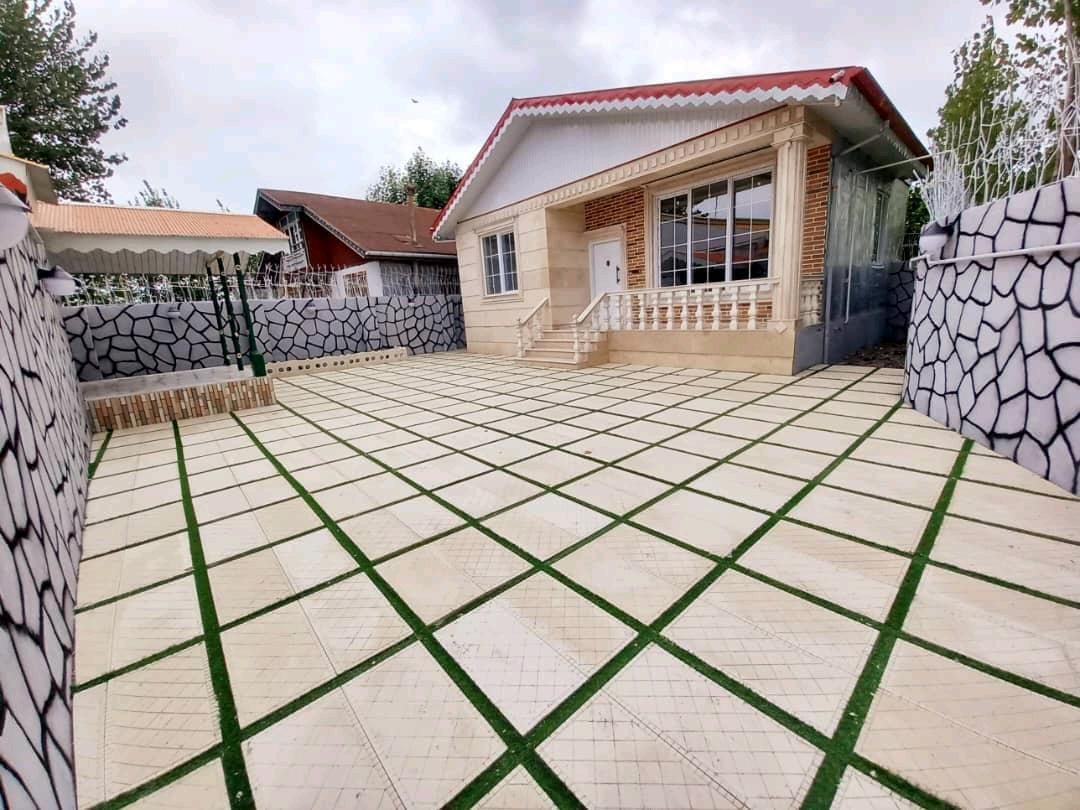 تصویر یک ویلای فلت روستایی که محوطه سازی شده و از چمن مصنوعی استفاده شده