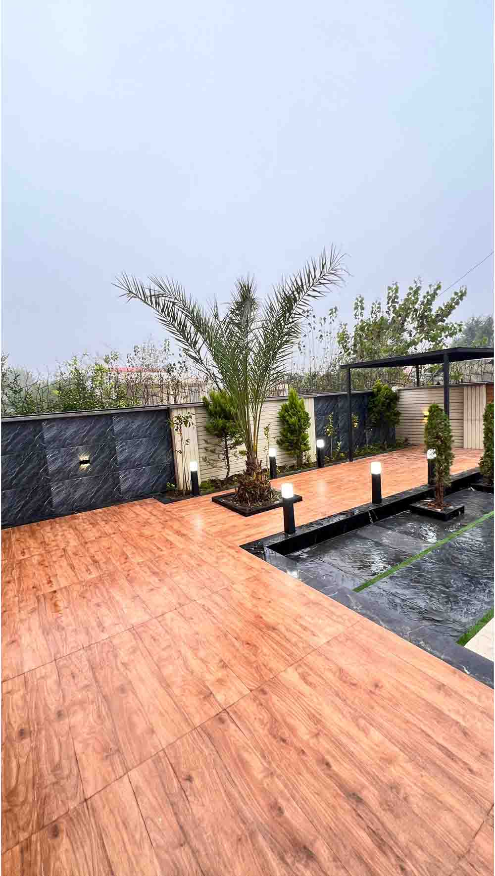 تصویر یک ویلای نما مدرن و محوطه سازی شده با موزاییک و چمن مصنوعی