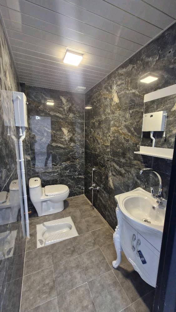 تصویر یک ویلای نما مدرن و محوطه سازی شده با موزاییک و چمن مصنوعی