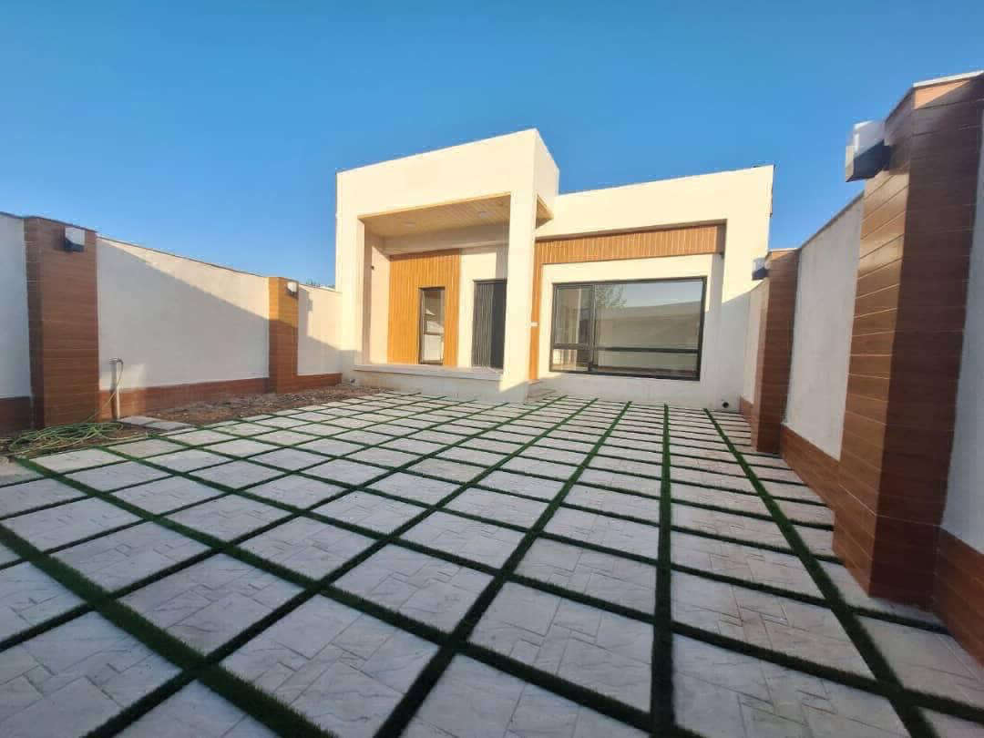 تصویر یک ویلای نما مدرن و محوطه سازی شده با موزاییک و چمن مصنوعی