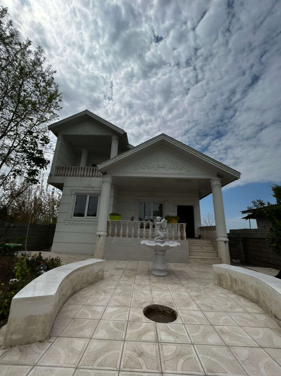 تصویر یک ویلای نما مدرن و محوطه سازی شده با موزاییک و چمن مصنوعی