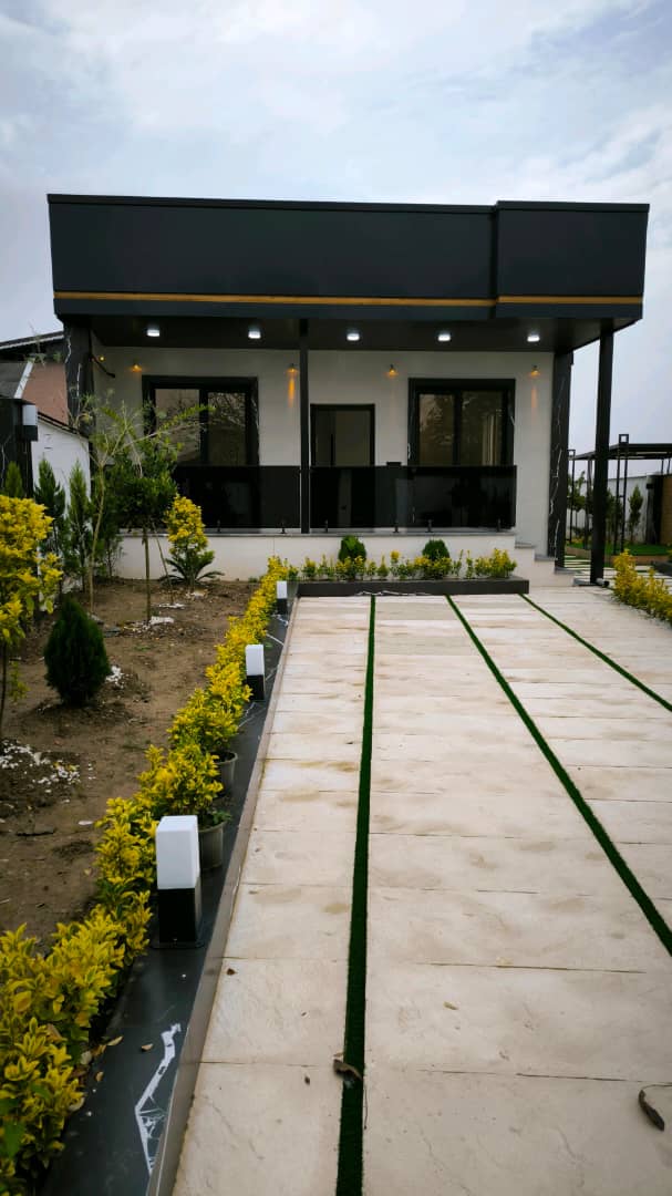 تصویر یک ویلای نما مدرن و محوطه سازی شده با موزاییک و چمن مصنوعی