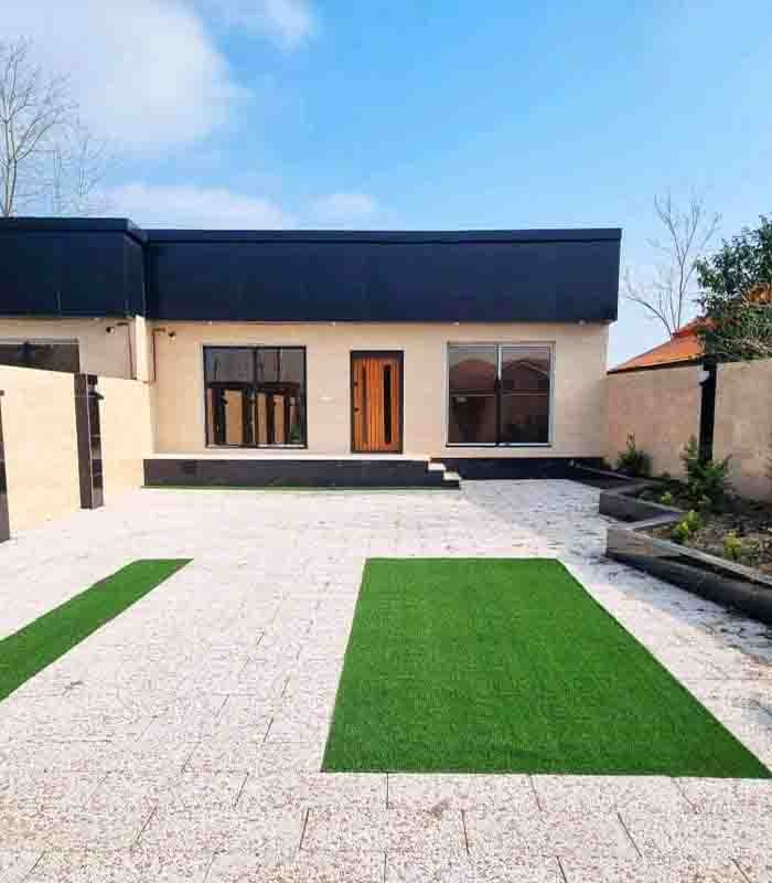 تصویر یک ویلای فلت روستایی که محوطه سازی شده و از چمن مصنوعی استفاده شده