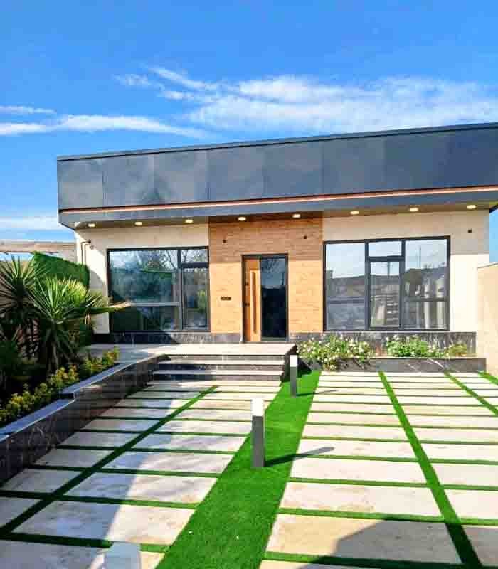 تصویر یک ویلای نما مدرن و محوطه سازی شده با موزاییک و چمن مصنوعی