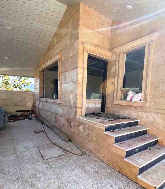 تصویر یک ویلای نما مدرن و محوطه سازی شده با موزاییک و چمن مصنوعی