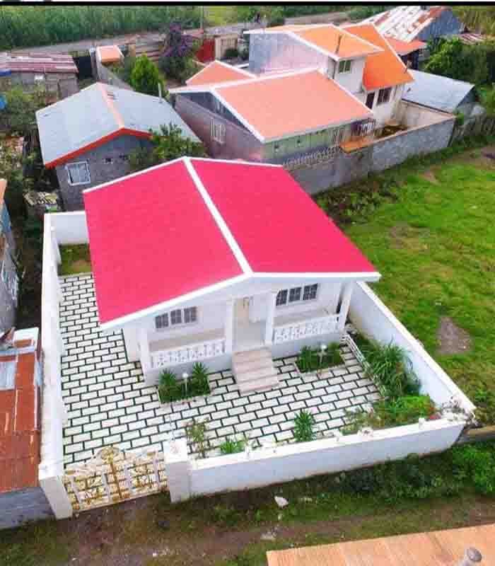 تصویر یک ویلای فلت روستایی که محوطه سازی شده و از چمن مصنوعی استفاده شده